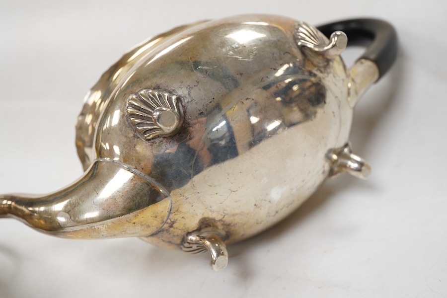 A late Victorian silver oval teapot, William Hutton & Sons, London, 1899, together with a George III silver cream jug, London, 1811, gross weight 15.4oz.